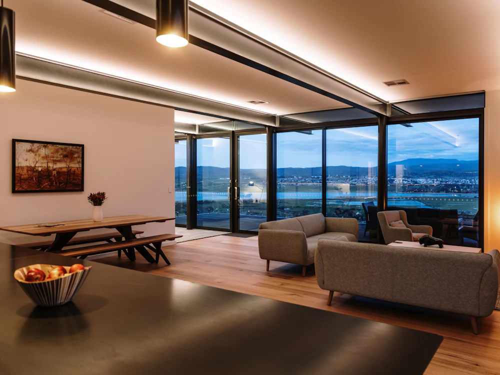 Modern living room with indirect ceiling lighting and large windows at dusk