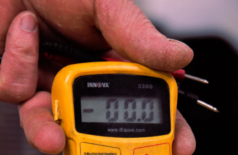 Hand holding a yellow multimeter